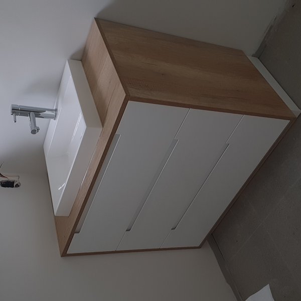 Wall-mounted chrome basin faucet over a floating vanity installed by Plumberz